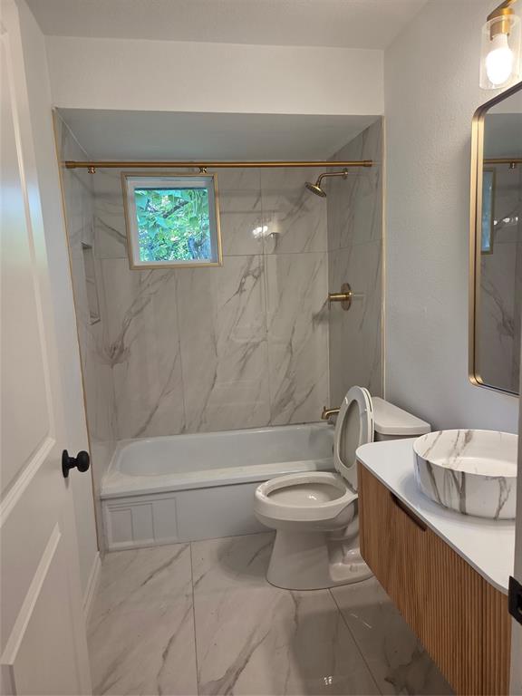 2108 Blake Avenue Dallas, TX 75228 - Photo 11 of 13 Secondary bathroom featuring a white bathtub with a shower, gold-finish fixtures, and a window
