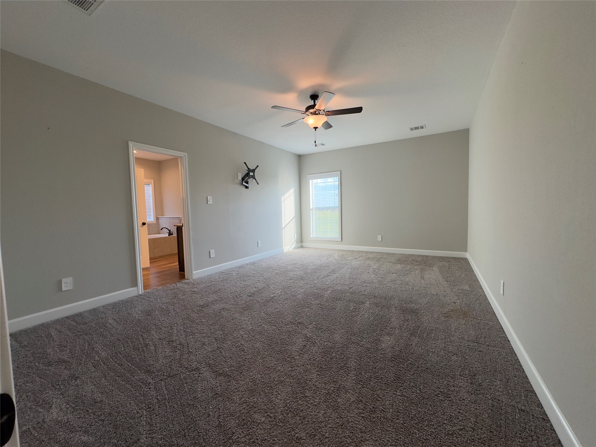 723 Sandy Corner Road El Campo, TX 77437 - Photo 14 of 20 a view of a big room with windows and chandelier fan