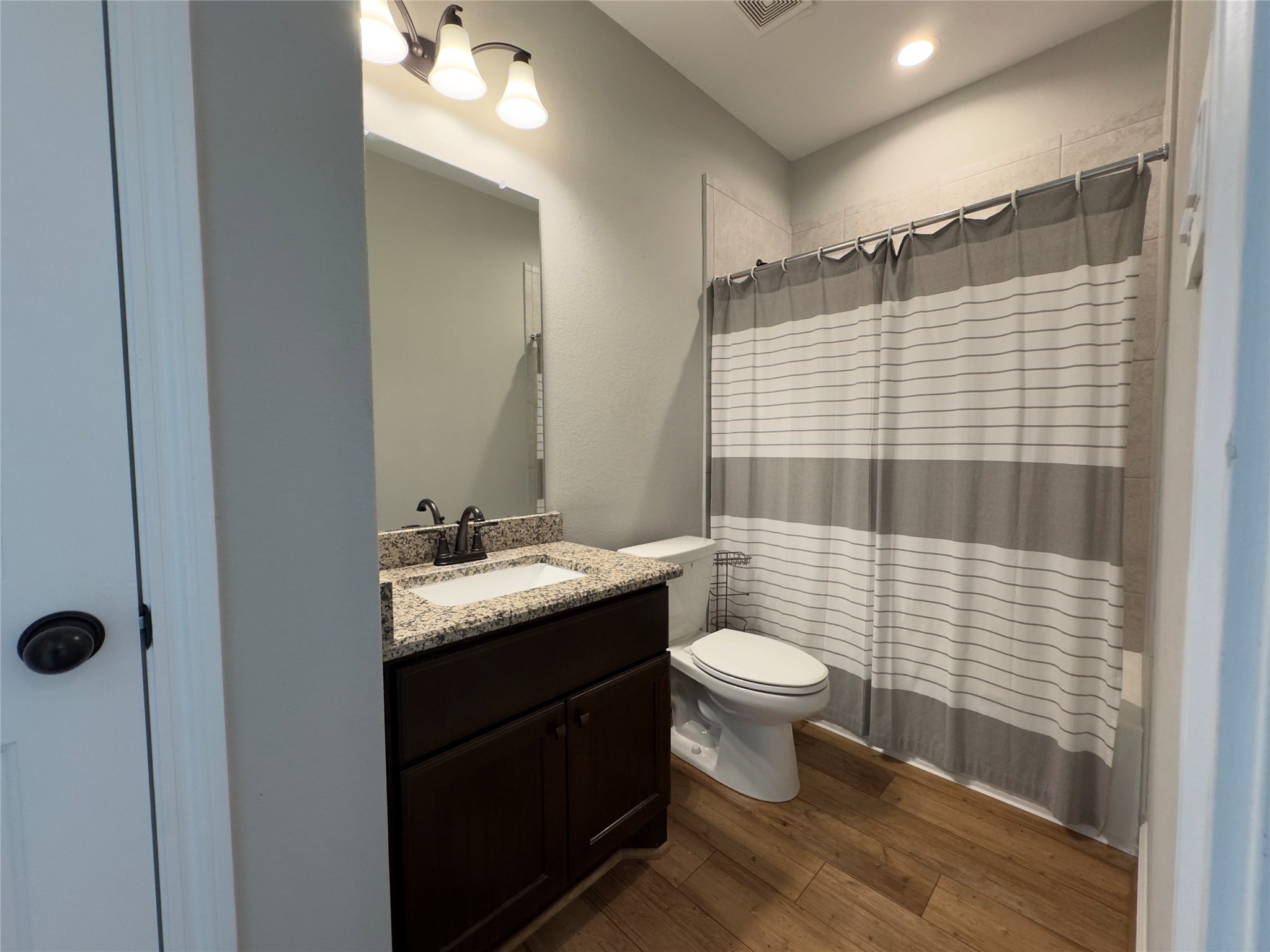 723 Sandy Corner Road El Campo, TX 77437 - Photo 16 of 20 a bathroom with a granite countertop sink toilet and shower