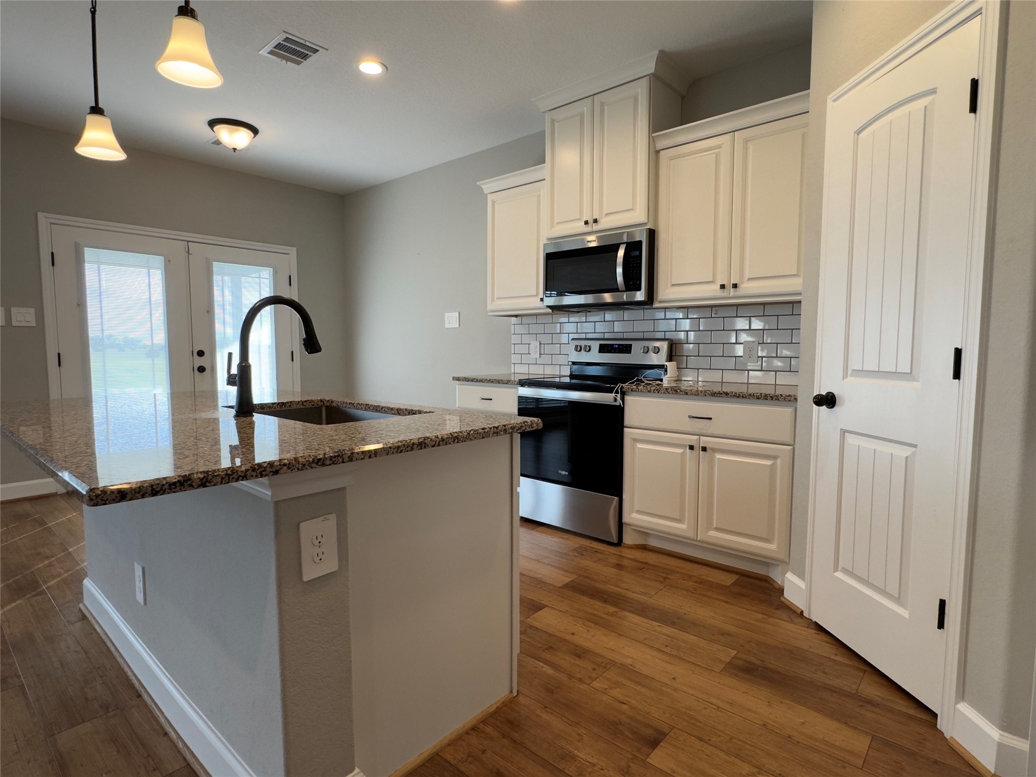 723 Sandy Corner Road El Campo, TX 77437 - Photo 7 of 20 a kitchen with stainless steel appliances granite countertop a stove top oven a sink a counter space and cabinets