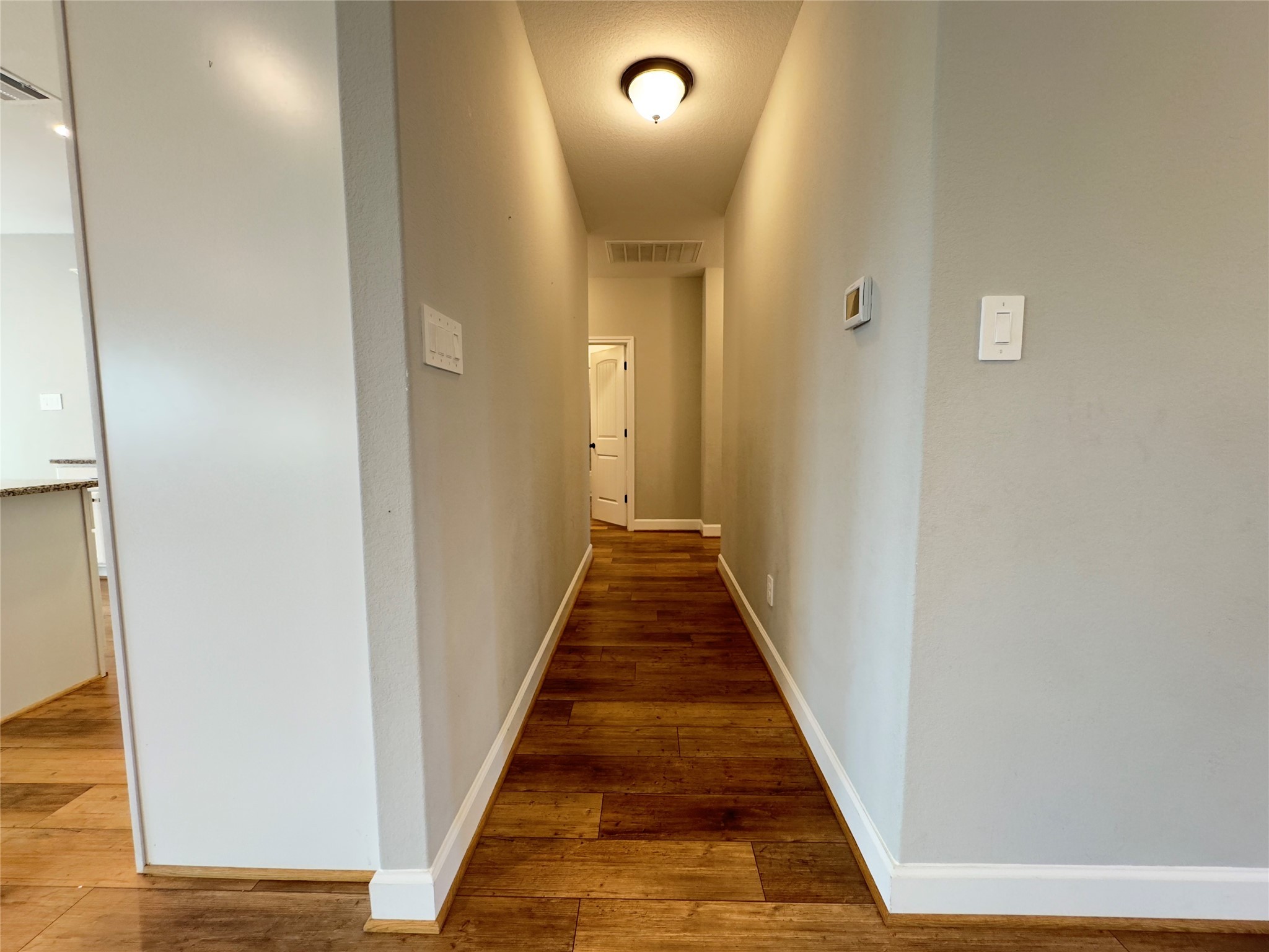 723 Sandy Corner Road El Campo, TX 77437 - Photo 10 of 20 a view of a hallway with wooden floor