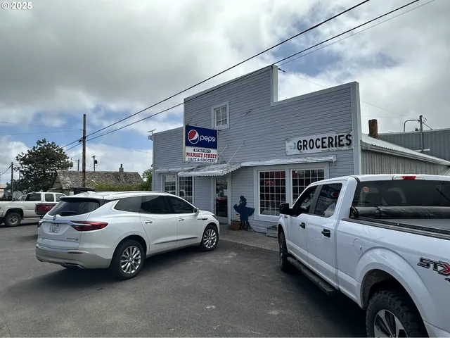 a backyard of a house with table and chairs a barbeque with a large tree