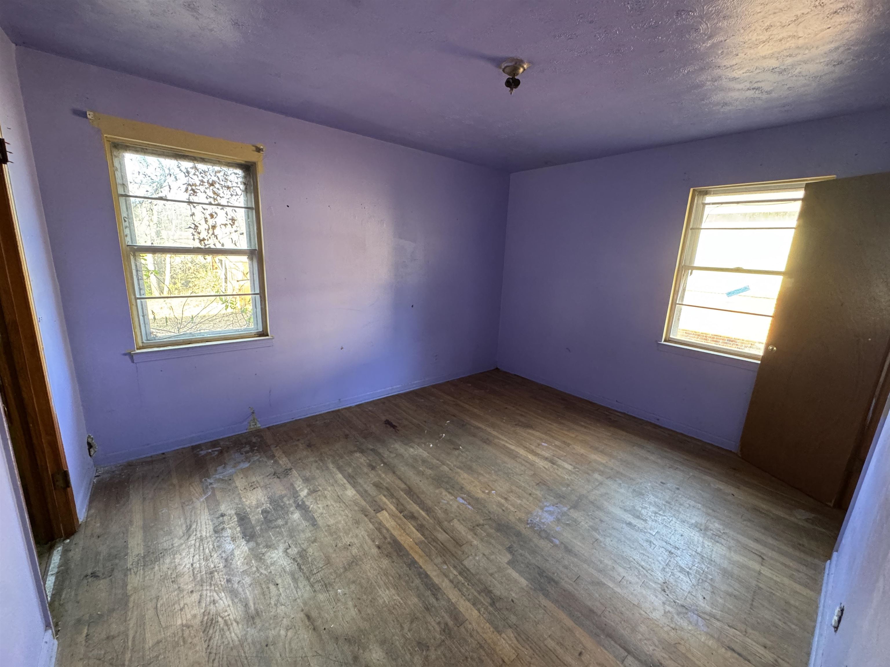 1640 Buxton Road Memphis, TN 38116 - Photo 12 of 16 Empty room featuring hardwood / wood-style floors, a healthy amount of sunlight, and a textured ceiling