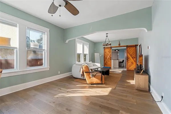 a living room with furniture chandelier and a large window