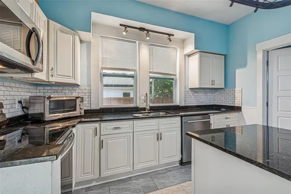 a kitchen with stainless steel appliances granite countertop a sink stove and cabinets