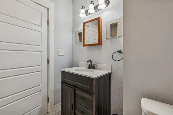 a bathroom with a sink a toilet and mirror