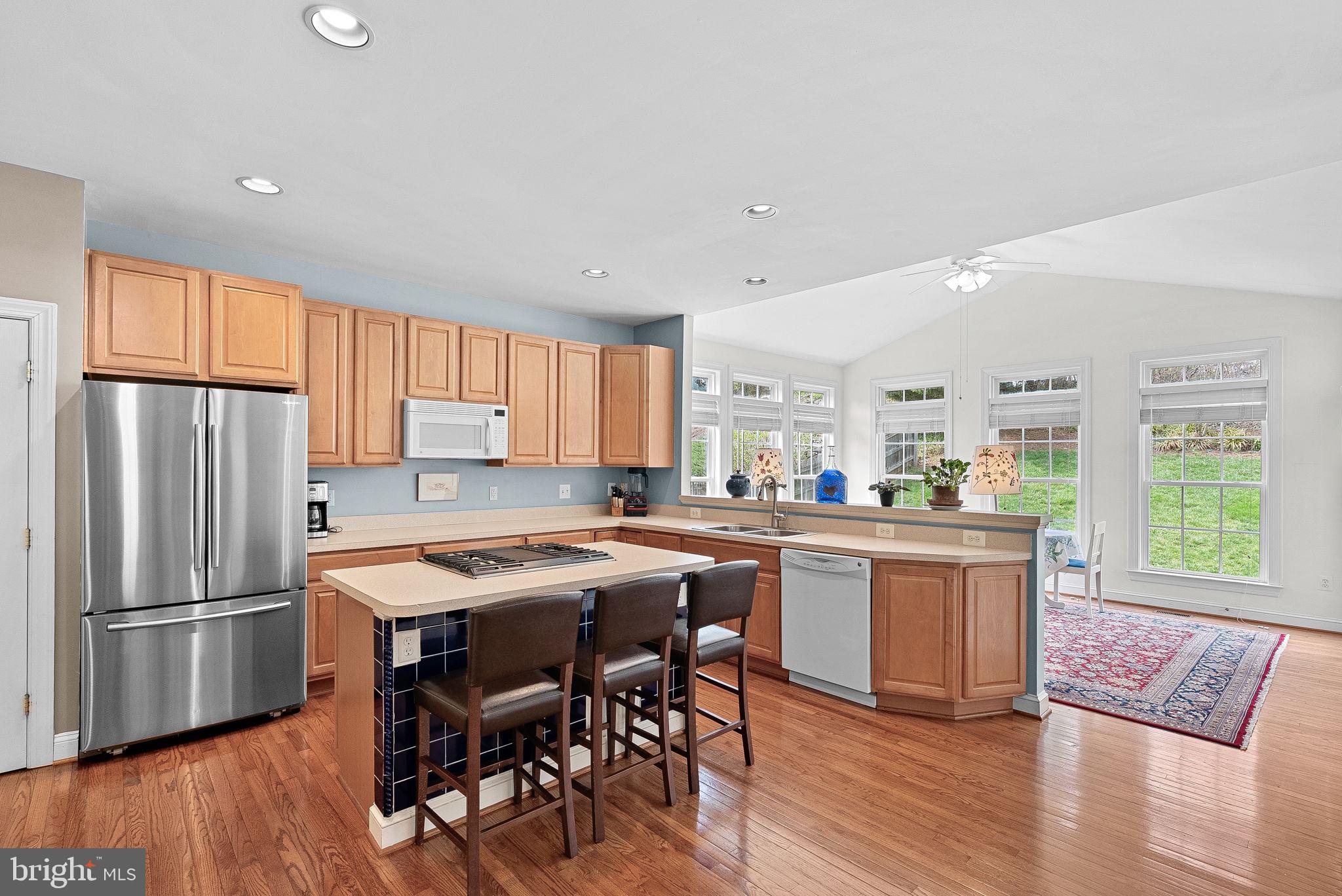 1921 Harvest Drive Winchester, VA 22601 - Photo 16 of 44 a kitchen with stainless steel appliances granite countertop a refrigerator a stove a sink a dining table and chairs with wooden floor