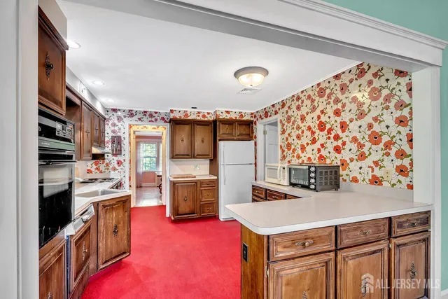 a kitchen with granite countertop a sink stove and refrigerator