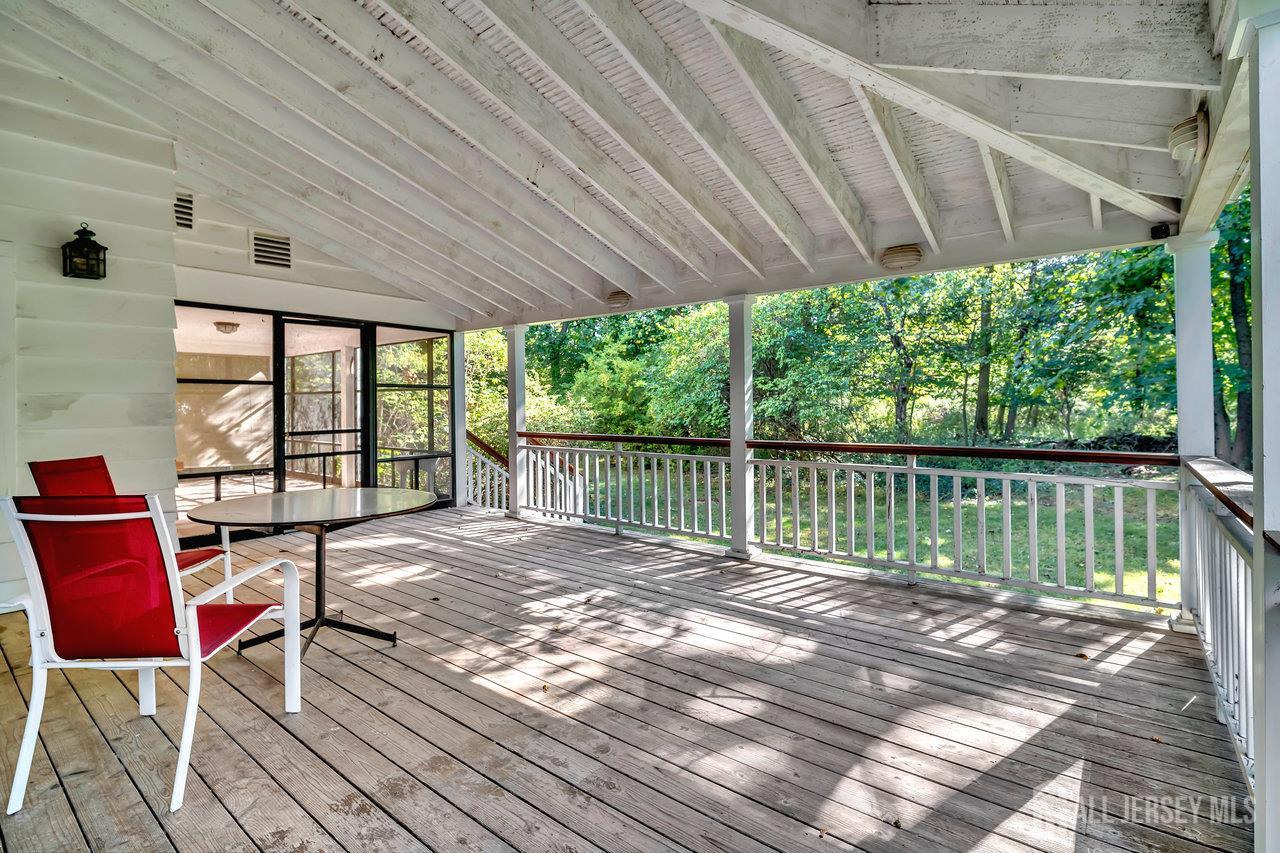 1010 River Road Piscataway, NJ 08854 - Photo 40 of 47 a roof deck with table and chairs under an umbrella with a small yard