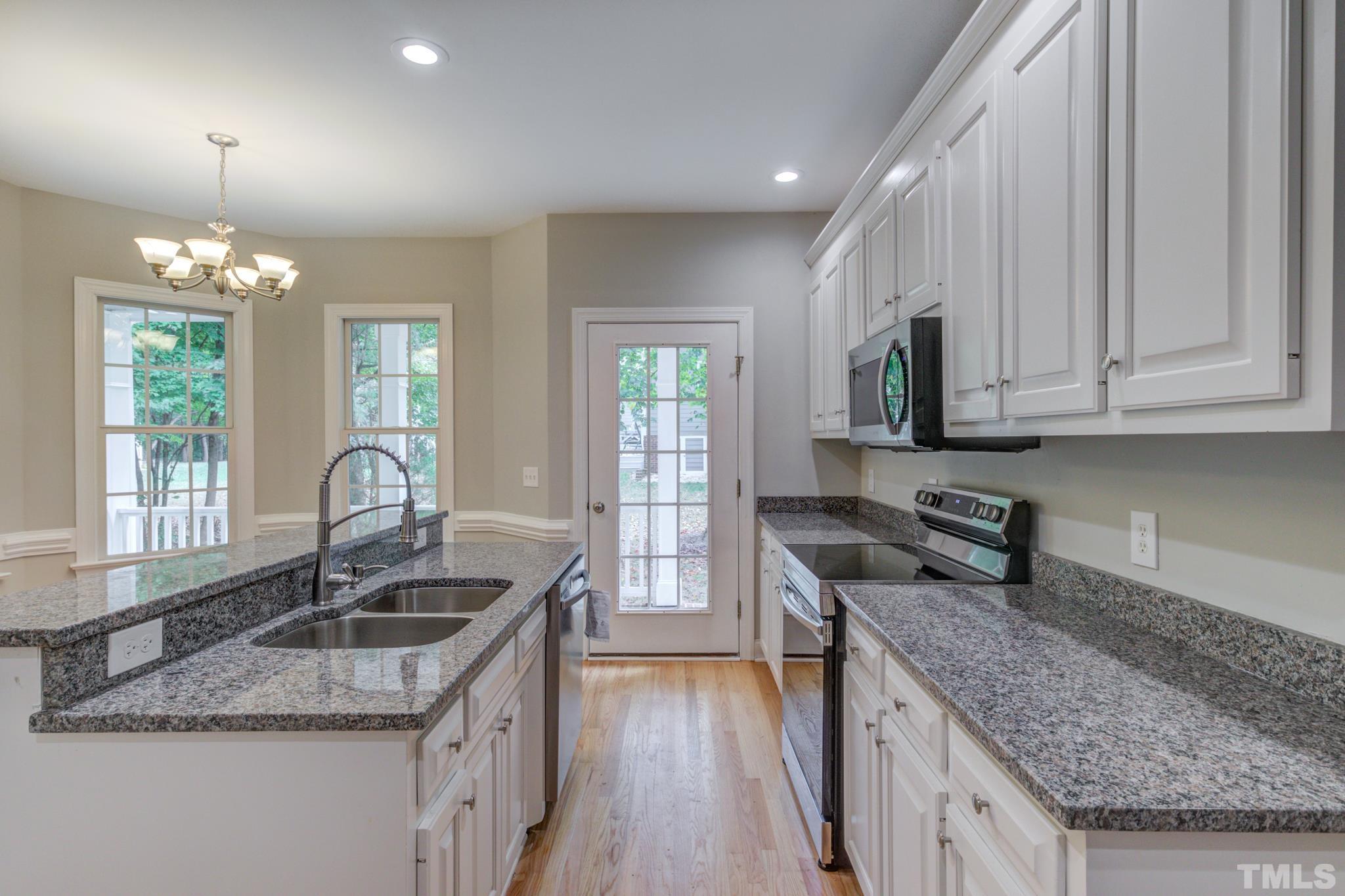 4425 Irene Way Raleigh, NC 27603 - Photo 8 of 28 a kitchen with granite countertop a sink a counter space appliances and cabinets