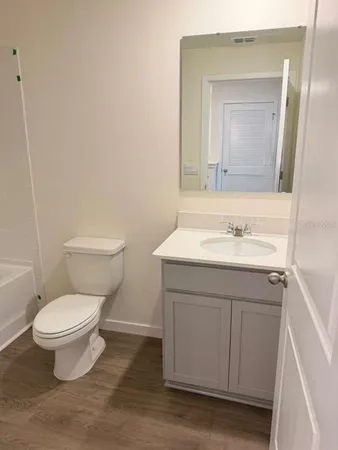a bathroom with a sink toilet a mirror and vanity