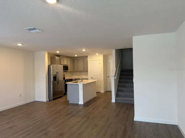 a kitchen with a refrigerator and a stove top oven