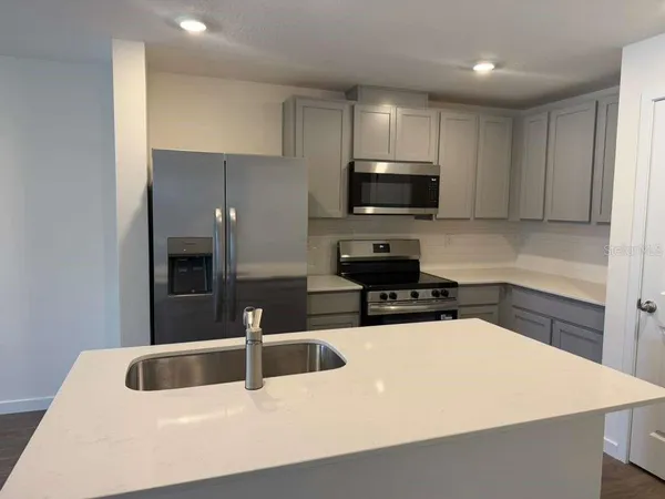 a kitchen with stainless steel appliances a refrigerator sink and microwave