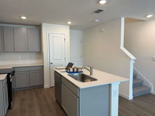 a kitchen with a sink cabinets and wooden floor