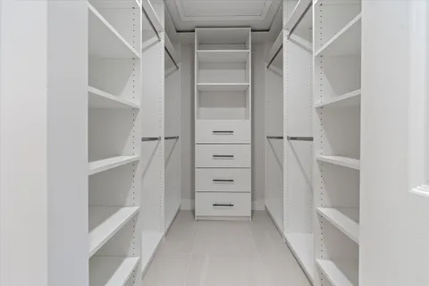 a view of walk in closet with empty racks