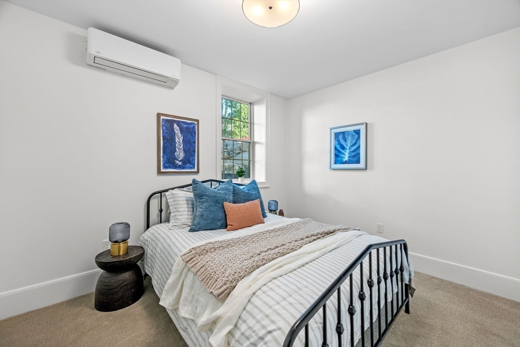 134 Elm Street, Unit 134 Marblehead, MA 01945 - Photo 22 of 38 a bedroom with a large bed and a chandelier