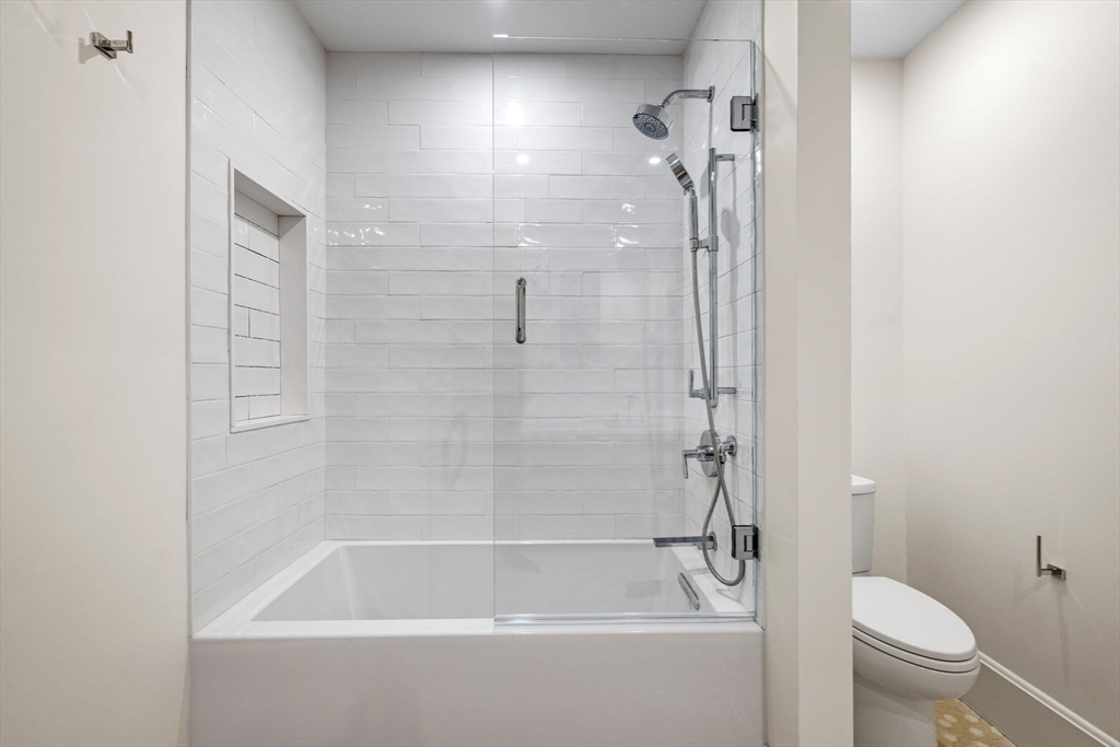 134 Elm Street, Unit 134 Marblehead, MA 01945 - Photo 25 of 38 a bathroom with a bathtub a toilet and a shower