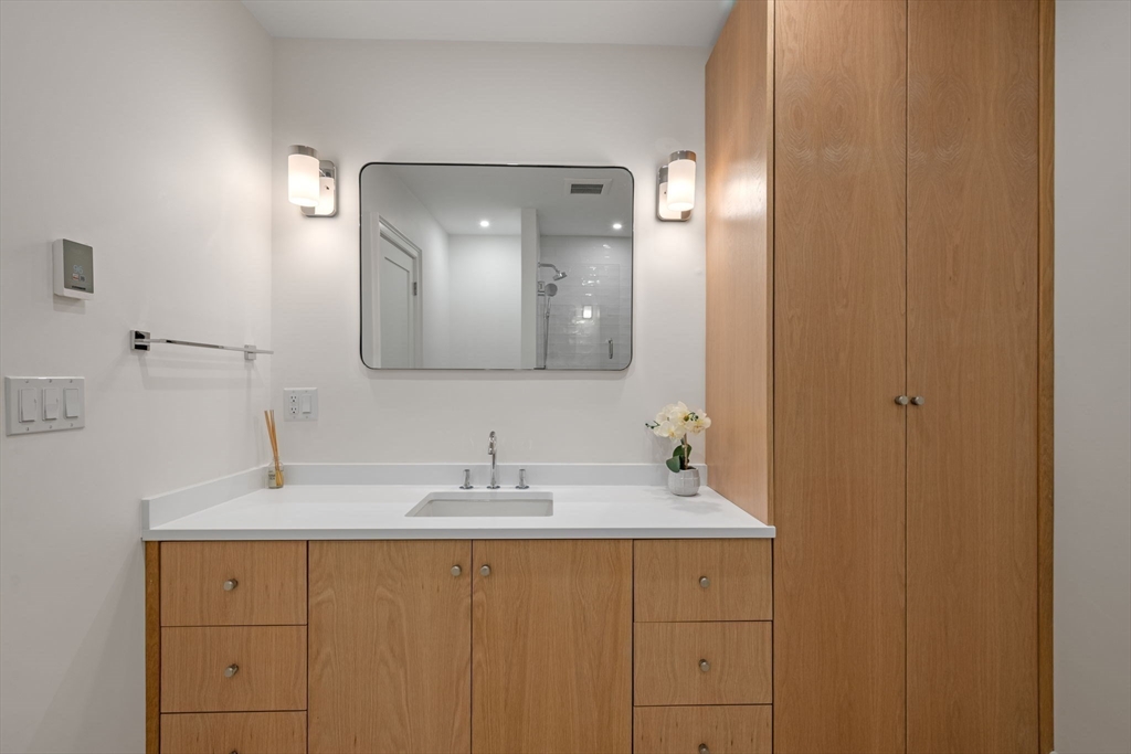 134 Elm Street, Unit 134 Marblehead, MA 01945 - Photo 26 of 38 a bathroom with a double vanity sink and a mirror