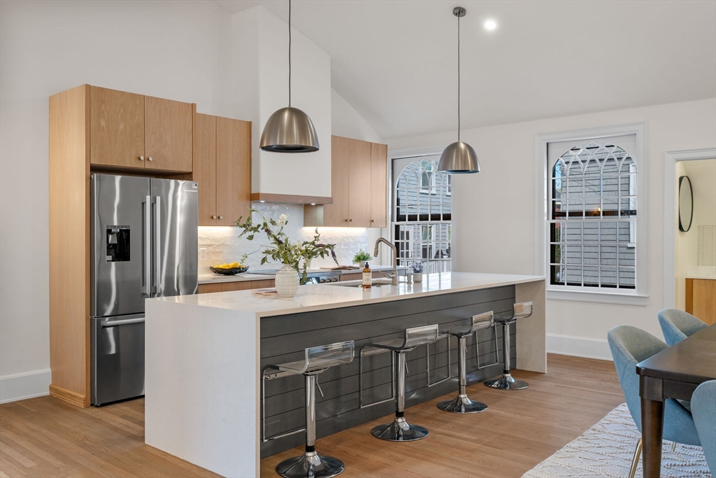 134 Elm Street, Unit 134 Marblehead, MA 01945 - Photo 3 of 38 a kitchen with kitchen island granite countertop a sink a center island and stainless steel appliances