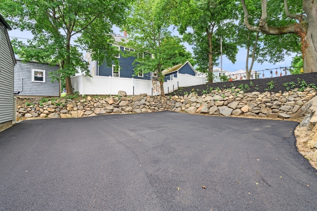 134 Elm Street, Unit 134 Marblehead, MA 01945 - Photo 35 of 38 a view of a house with a yard and covered with tall trees