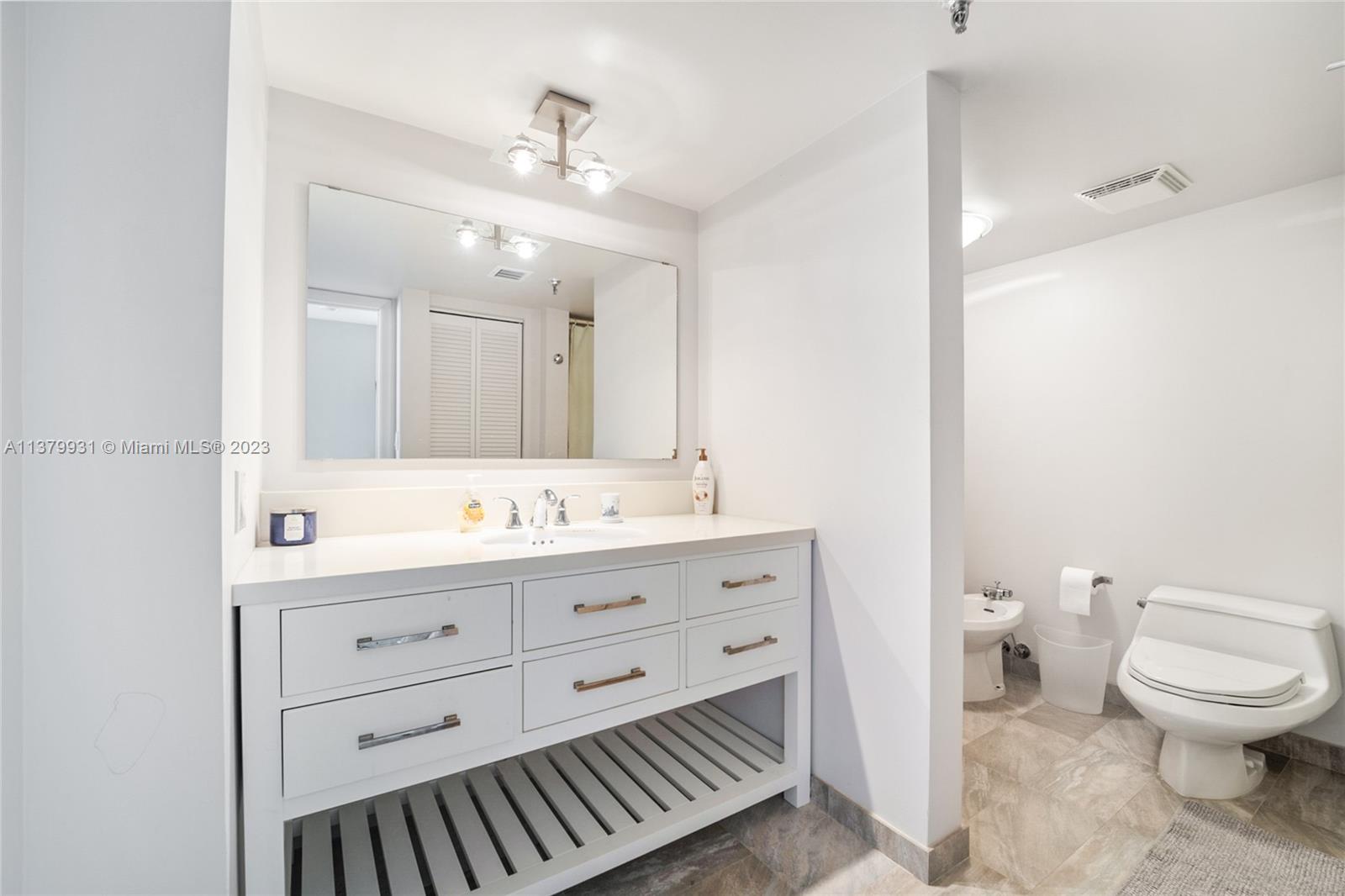 520 Brickell Key Drive, Unit APH10 Miami, FL 33131 - Photo 11 of 23 a bathroom with a toilet a sink a mirror and a shower