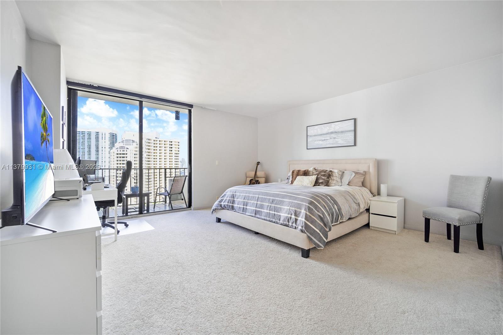 520 Brickell Key Drive, Unit APH10 Miami, FL 33131 - Photo 15 of 23 a bedroom with a bed and a flat tv screen next to a large window