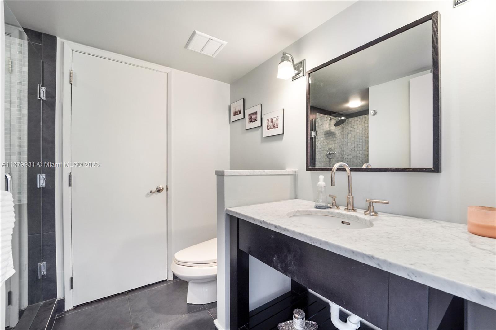 520 Brickell Key Drive, Unit APH10 Miami, FL 33131 - Photo 10 of 23 a bathroom with a toilet a sink a mirror and vanity