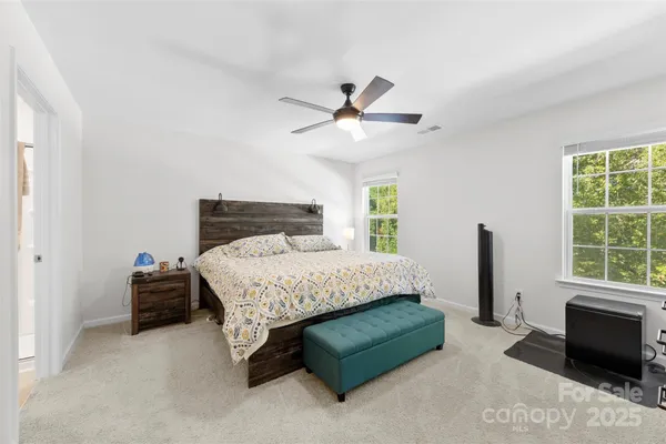 a bedroom with a bed a window and a chandelier