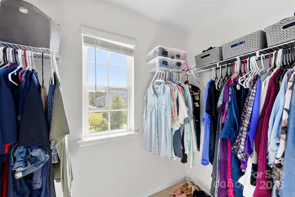 a view of walk in closet with clothes and shoes