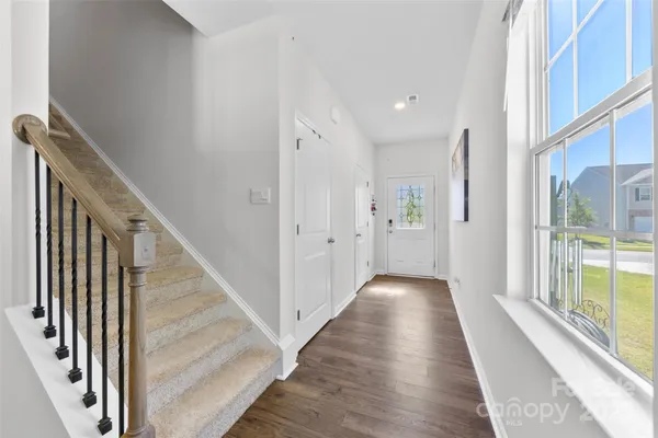 a view of a hallway with wooden floor and staircase