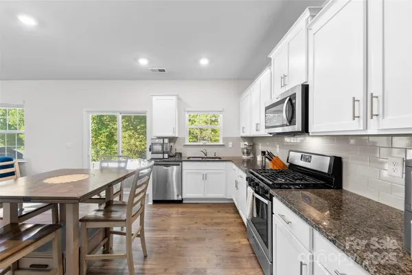 a kitchen with a stove a sink a microwave and cabinets