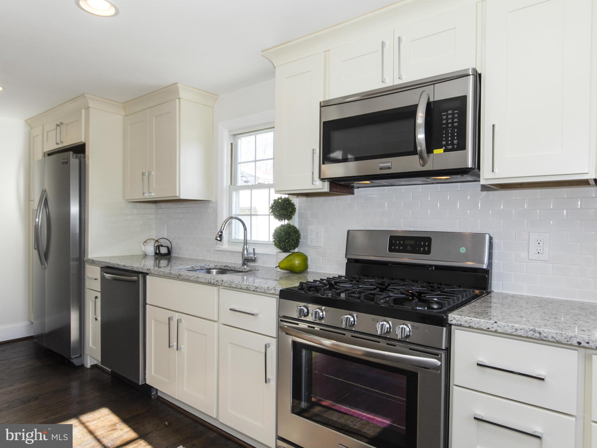 707 Elmwood Road Baltimore, MD 21206 - Photo 14 of 30 a kitchen with stainless steel appliances granite countertop white cabinets a stove a sink and dishwasher