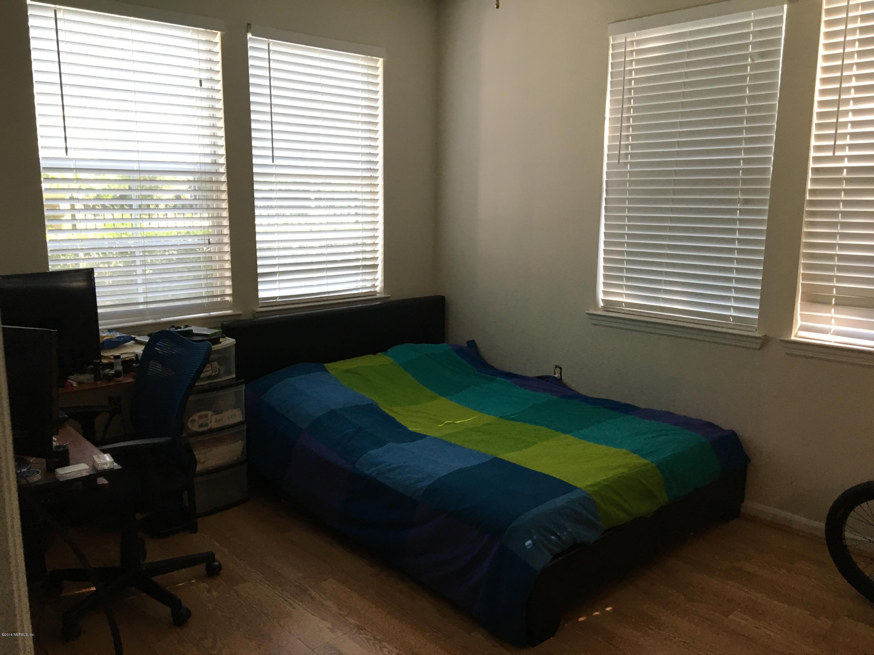 8550 Touchton Road, Unit 118 Jacksonville, FL 32216 - Photo 7 of 10 a bedroom with a bed window and a chair