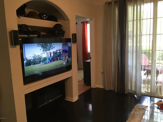 a living room with flat screen tv and a fireplace