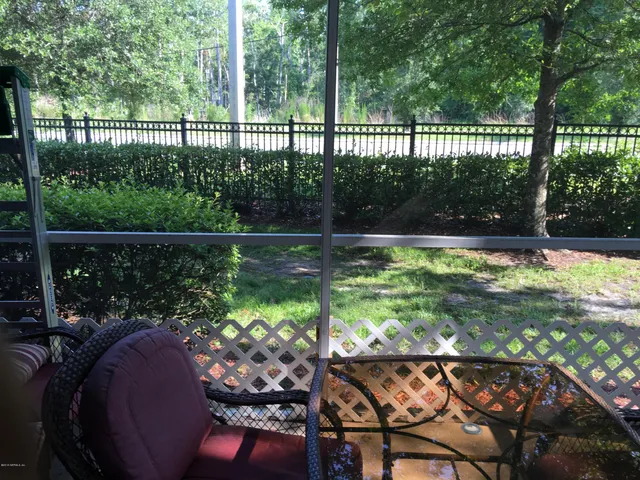 a view of a back yard from a balcony with outdoor seating