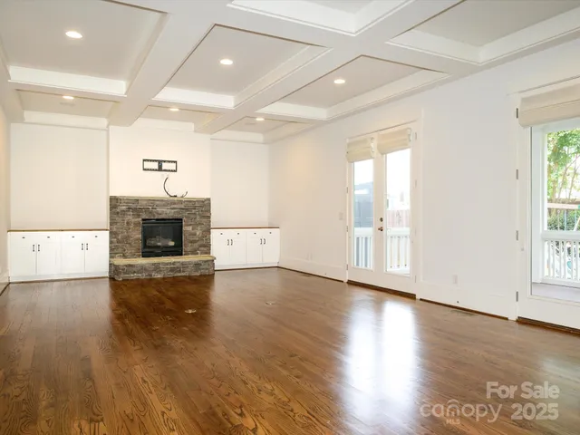 an empty room with wooden floor and a fireplace