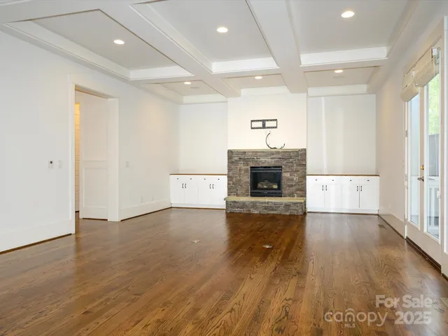an empty room with wooden floor and fireplace