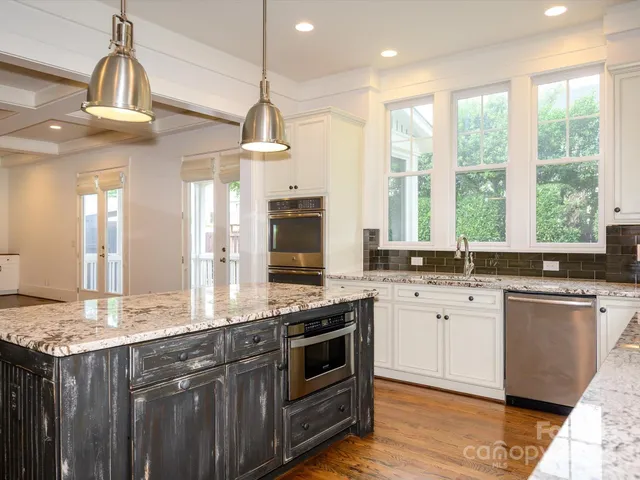 a kitchen with stainless steel appliances granite countertop a stove a sink and a refrigerator