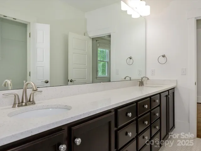 a bathroom with a double vanity sink and a mirror
