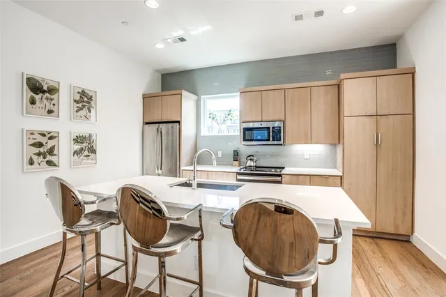 a kitchen with sink a stove a refrigerator and microwave