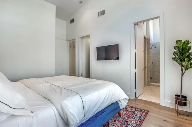 a bedroom with a bed wooden floor and potted plant