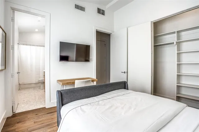 a bedroom with a bed and a flat screen tv