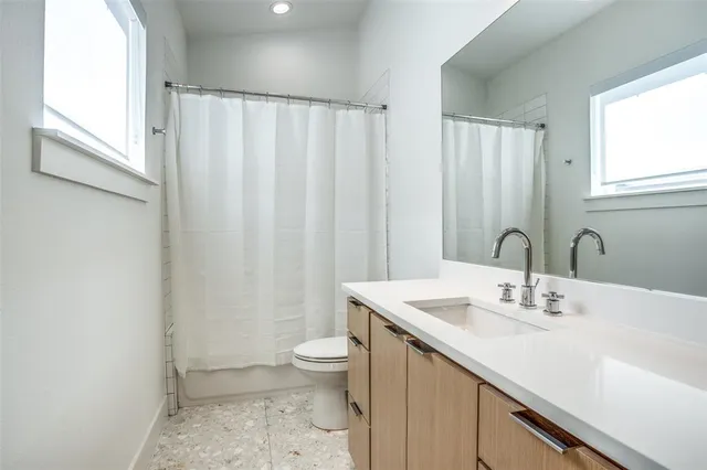 a bathroom with a sink a toilet and a mirror