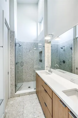a spacious bathroom with a shower sink and mirror