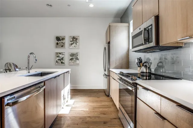 a kitchen with stainless steel appliances granite countertop a sink stove and refrigerator