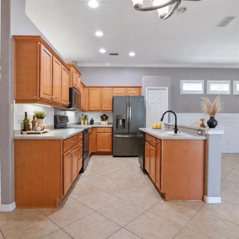 12150 Mapleridge Drive Parrish, FL 34219 - Photo 16 of 45 a kitchen with stainless steel appliances granite countertop a sink and a refrigerator