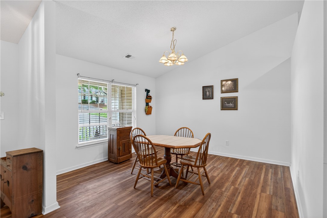 207 Hunters Lane Anderson, SC 29625 - Photo 18 of 46 A charming dining space with vaulted ceilings and rich wood flooring, perfect for everyday meals. This formal dining room could also be used as an office space or den area.