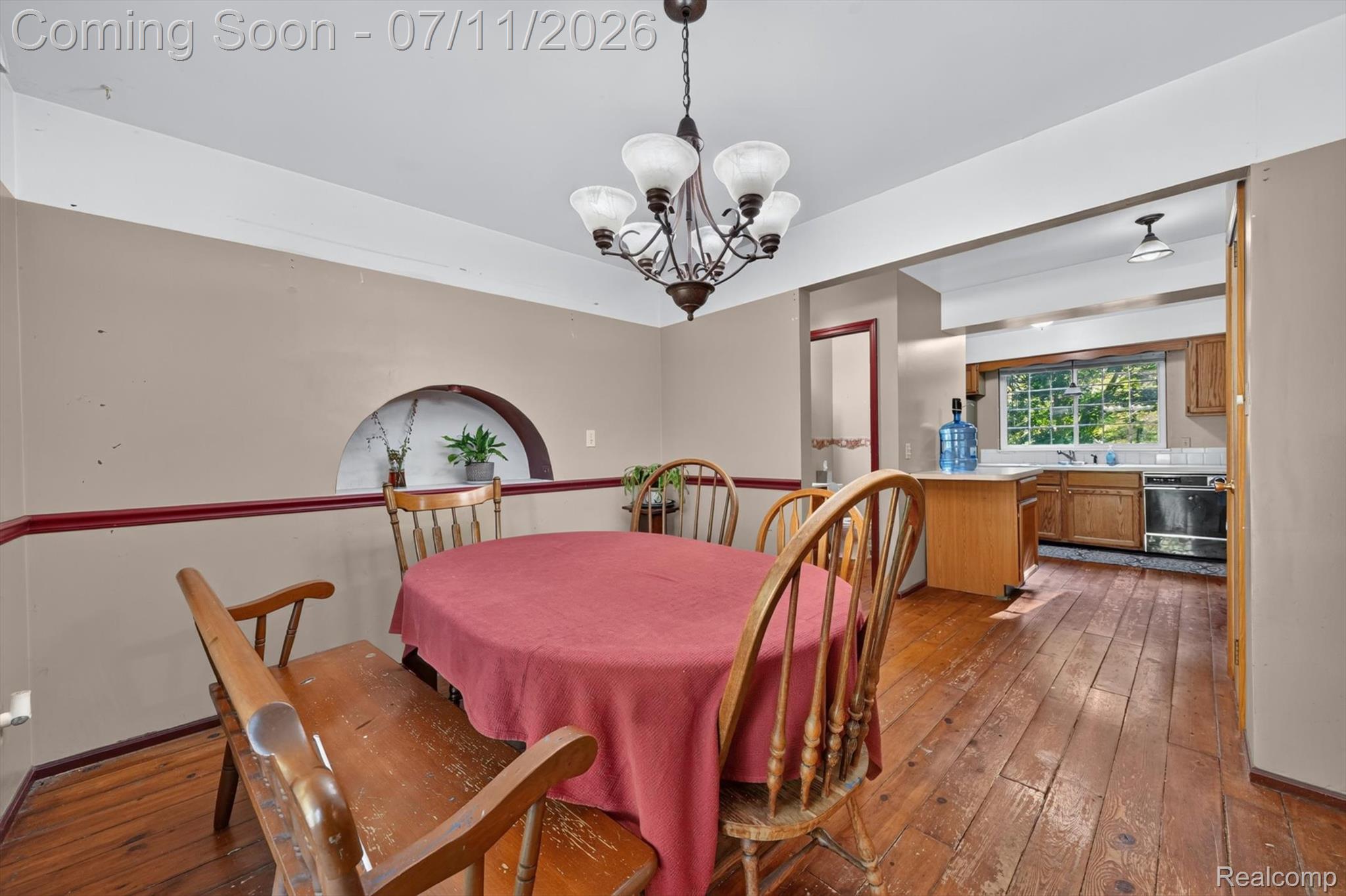 4430 North Center Road Flint, MI 48506 - Photo 8 of 49 Dining area featuring wood-finish flooring, a decorative arched wall niche, and a chandelier with glass shades