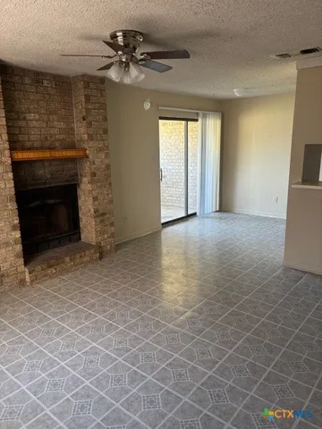 an empty room with windows and fireplace