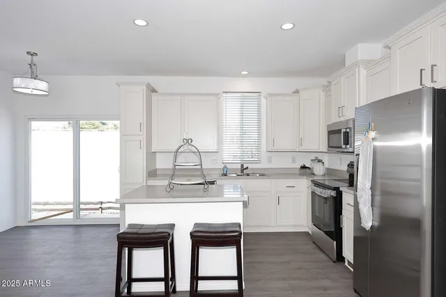 a kitchen with a sink a window and stainless steel appliances